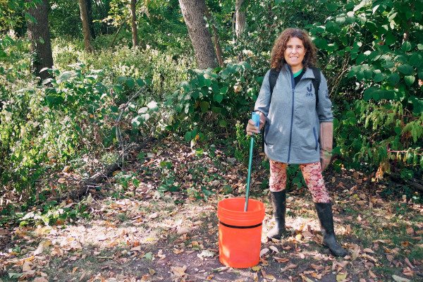 A volunteer picking up litter from a roadside.