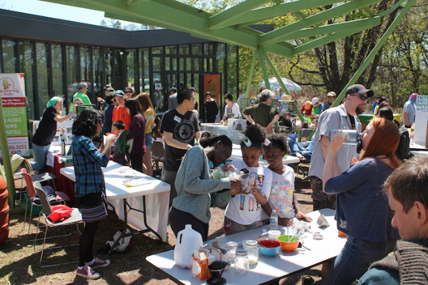Tables of children doing craft projects outdoors.